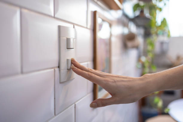 Caucasian woman turning on light by switch