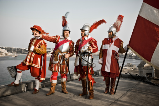 Group of Knights from Malta on the top of Fort Sant Elmo with Maltese Flag, Historical Reenactment in Valetta, Malta. Knights Group Portrait. Personal Editing
