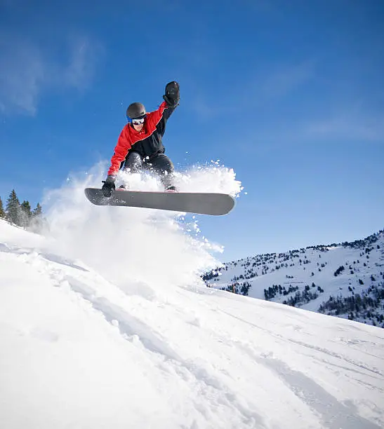 Snowboarder getting air in the Alpine back country.