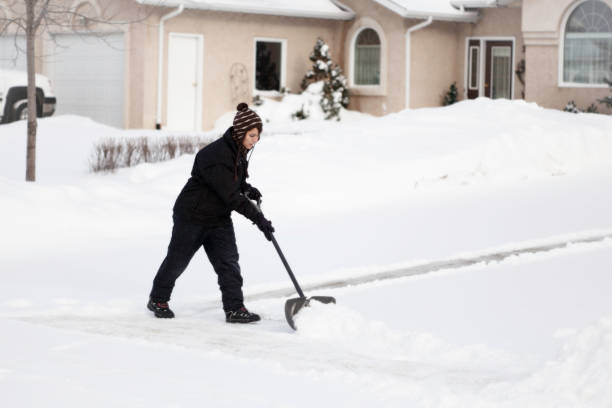 Female shoveling snow on driveway
