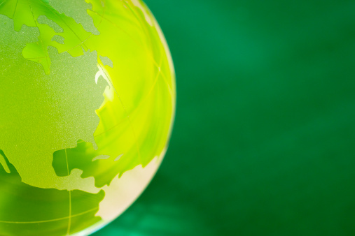 Glass globe on the green background. Focus on America and Canada