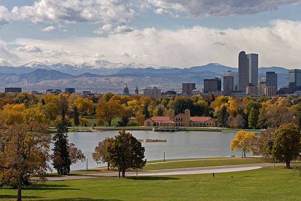 Landscape of the downtown Denver skyline in the fall A person walks through Denver's city park with fall colors,downtown skyline and Mount Evans in the background, Colorado. civic center park stock pictures, royalty-free photos & images