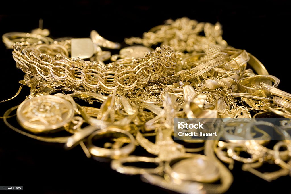Several pieces of gold jewelry in a pile Broken, damaged and pieces of 14k gold jewelry. This is to be weighed and melted down for new jewelry. Jewelry Stock Photo