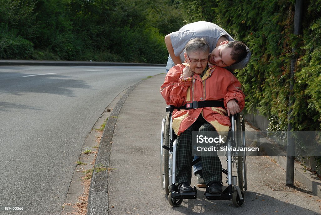 taking care young man taking care of a senior woman in wheelchair Family Stock Photo