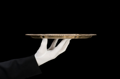 Silver platter being held by a white gloved hand with black sleeve on black background.it's waiting to hold whatever you want.1of6 tray presentations. see lightbox below.http://www.garyalvis.com/images/conceptsIdeas.jpg
