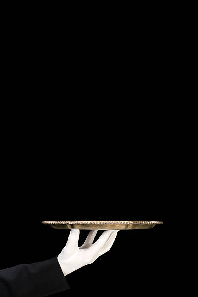istock Silver Platter held by white gloved hand/isolated on black-vertical 157400732