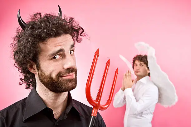 Photo of black devil with curly hair and angel on background
