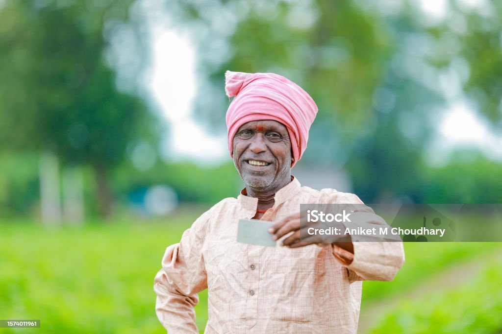 Indian farmer Holding gullak in hand, saving concept, happy poor farmer Indian farmer Holding ATM card in hands , happy indian farmer, poor farmer, worker 50-54 Years Stock Photo