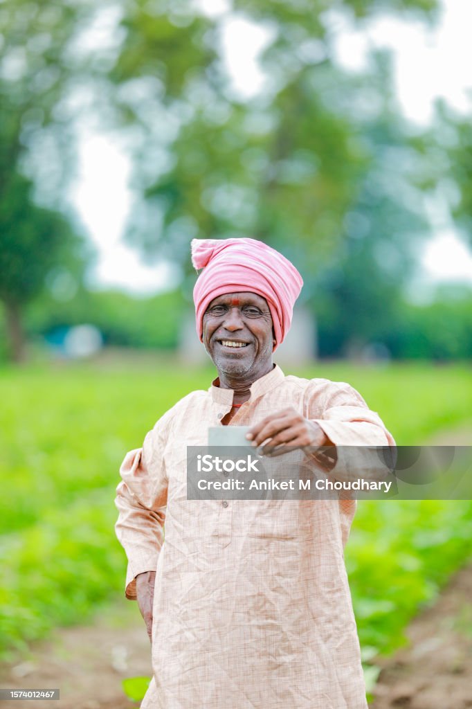 Indian farmer Holding gullak in hand, saving concept, happy poor farmer Indian farmer Holding ATM card in hands , happy indian farmer, poor farmer, worker 50-54 Years Stock Photo