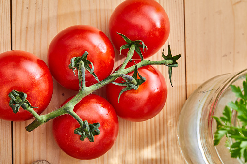 Beautiful red ripe fresh organic tomato on the kitchen table, home or restaurant, representing a health lifestyle, wellbeing and body care.