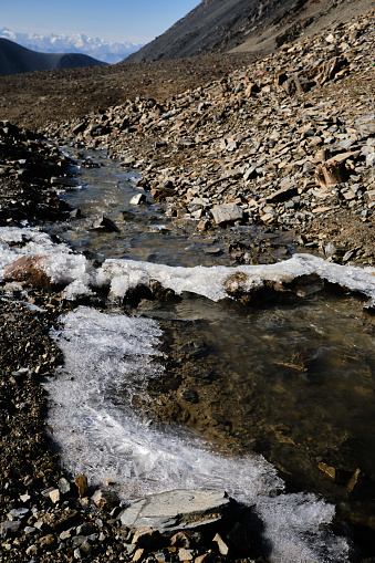 Mountain creek under ice crust. Arabel plateau, Tien Shan mountains, Kyrgyzstan