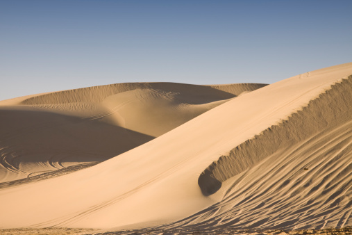 Badain Jaran Desert in Inner Mongolia, China, the third largest desert in China, with the tallest stationary dunes on Earth blue sky, white clouds in background, black and white