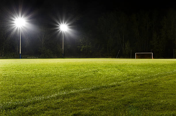 Soccer Field at Night Groomed soccer field or soccer pitch at night.  Real, green grass, stadium style lighting and dark skies isolate the field from its surroundings.  The field is empty with no players. baseline stock pictures, royalty-free photos & images