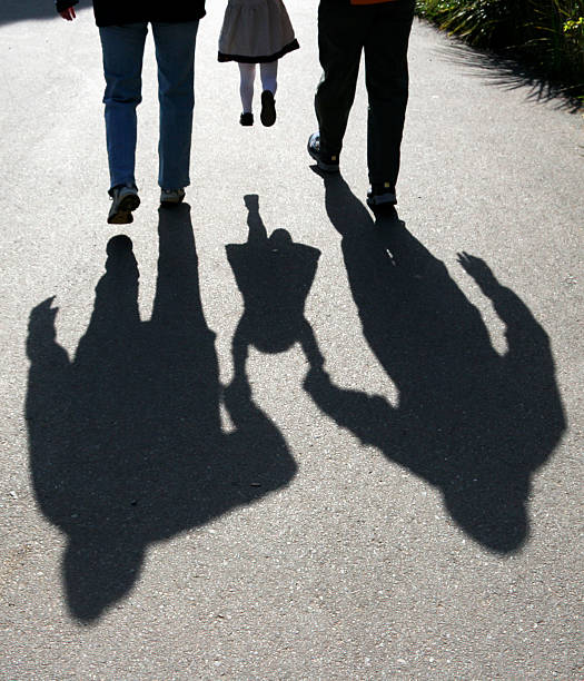 sombras de los padres hacen niño - holding hands child silhouette family fotografías e imágenes de stock