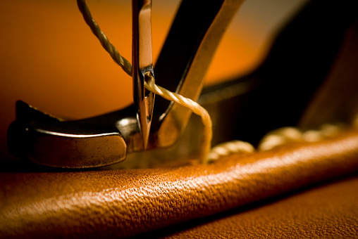 Macro, close-up of needle penetrating leather