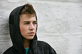 Teen Boy with Hoodie in front of Old White Wall
