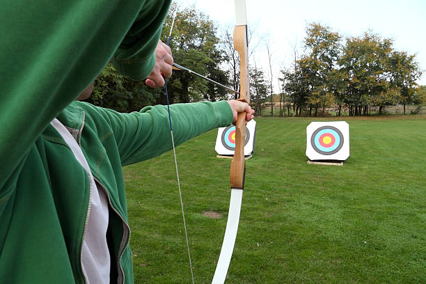 Archery firing at targets on a grass field stock photo