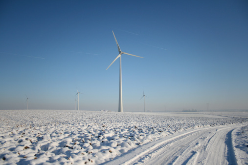Wind turbine on snowy field in winter. Alternative energy. Aerial view of nature in Poland, Europe