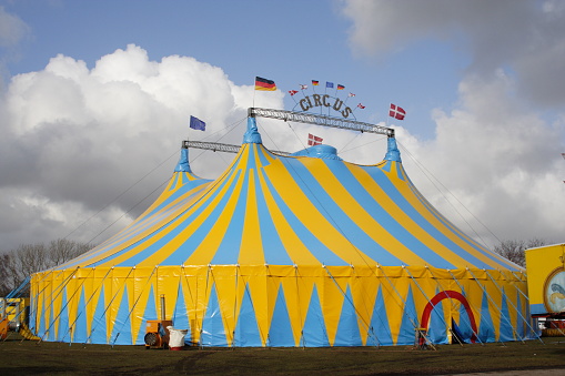 Circus tent blue, yellow and white striped pattern  with Brazil and Sao Paulo state  flag, against the blue sky