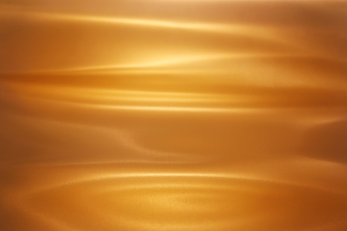 Sheet of brushed gold. Lighting and reflections make it look like a pool of melted gold. All light and shadow created with lighting techniques.