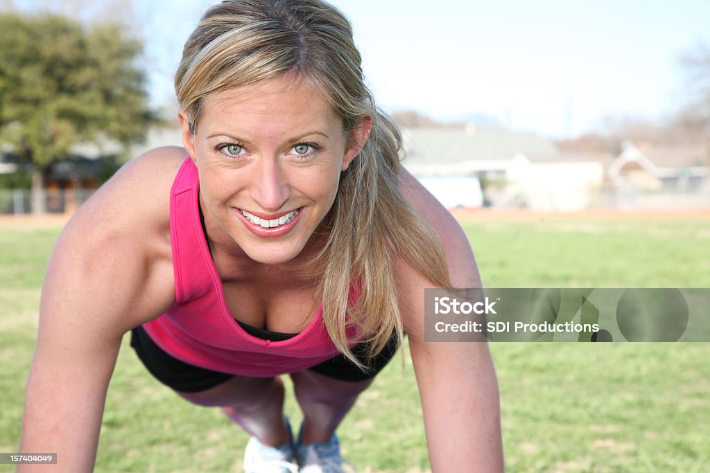 Felice Fit donna fare Push-up su un campo di ricerca - Foto stock royalty-free di Donne