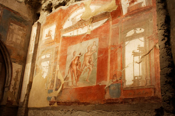 Ancient remnants of Pompeii captured under vivid sunlight. The scenery highlights the textures and history of this famous archeological site, showing stone walls and alleys with a picturesque background.