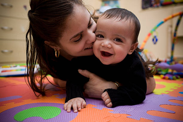 Adorable Hispanic Young Mother and Son in Home Playroom stock photo