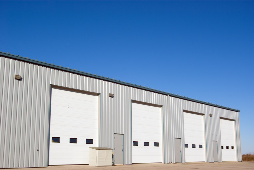 An industrial warehouse with four large drive-in doors.
