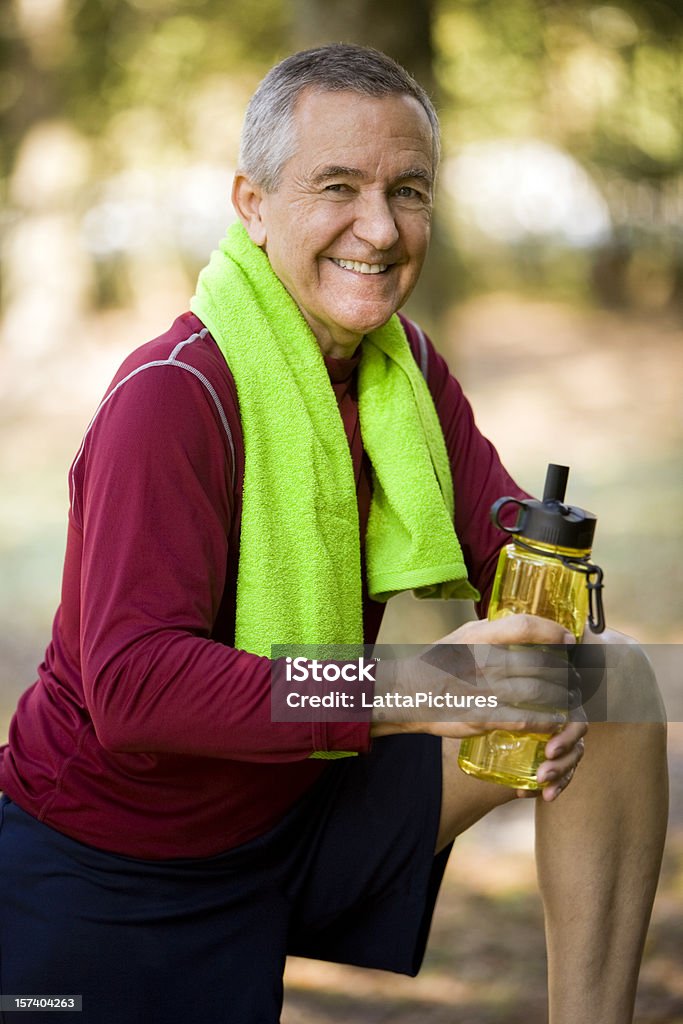 Sorrindo homem sênior roupas e segurando uma garrafa de água - Foto de stock de Adulto royalty-free