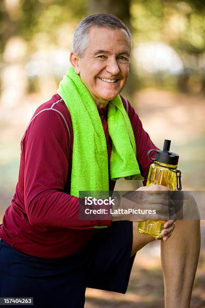 Foto de Sorrindo Homem Sênior Roupas E Segurando Uma Garrafa De Água e mais fotos de stock de Adulto