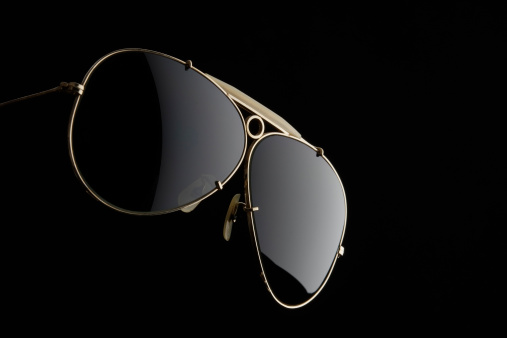 Sunglasses with light isolated on black background.