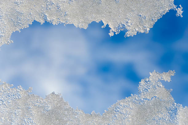 View of snow through a window or roof light and blue sky stock photo