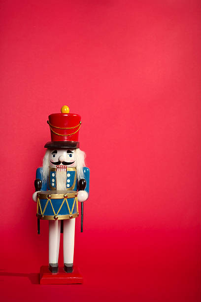 Portrait of a wooden nutcracker on light red background Nutcracker Toy Soldier on red background.....To See more HOLIDAY IMAGES Please click this Image : nutcracker photos stock pictures, royalty-free photos & images