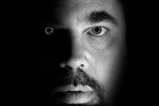 Face Close-up portrait. An exercise in light and shadow. creepy stalker stock pictures, royalty-free photos & images