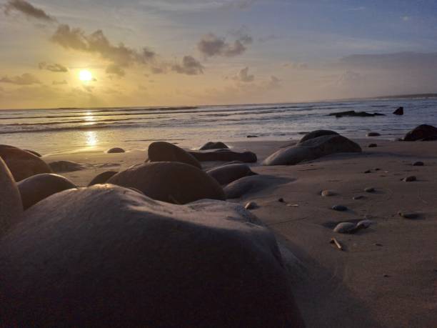 istock Rocks on the beach with clear weather when the sun sets 1574045825