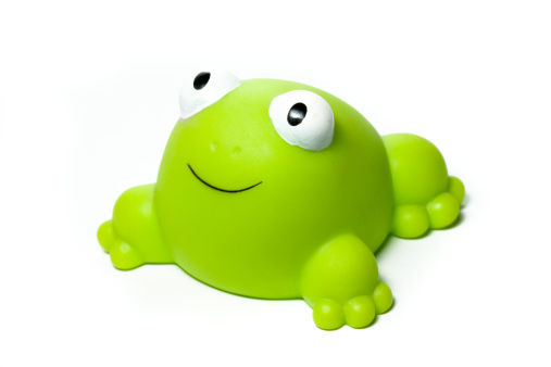 Portrait of a funny and smiling green rubber frog, isolated on white. Ideal for conveying any children and/or play related concepts.