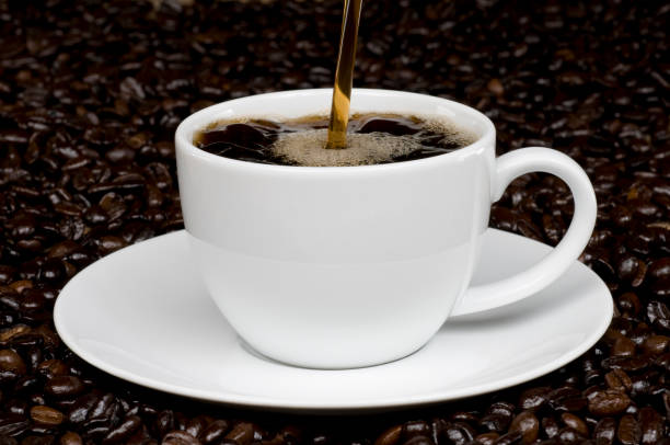 istock Hot Coffee Being Poured Into a White Mug and Saucer 157405293