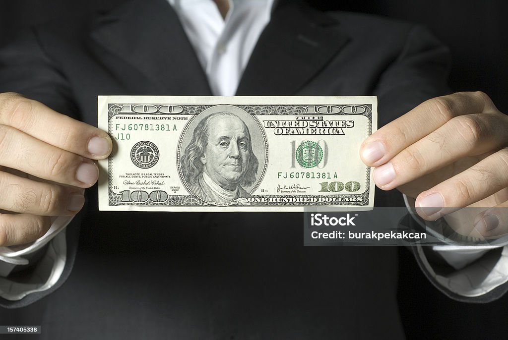 Uomo d'affari tenendo 100 dollari US NOTA: - Foto stock royalty-free di Valuta