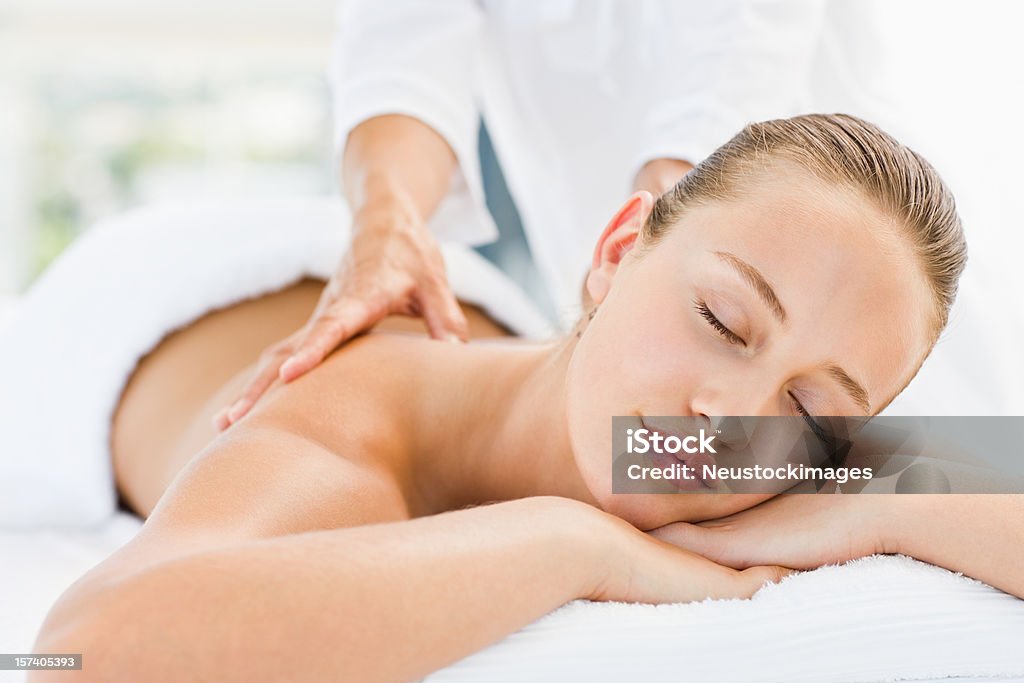 Mujer joven recibiendo un masaje de espalda en el spa - Foto de stock de 20 a 29 años libre de derechos