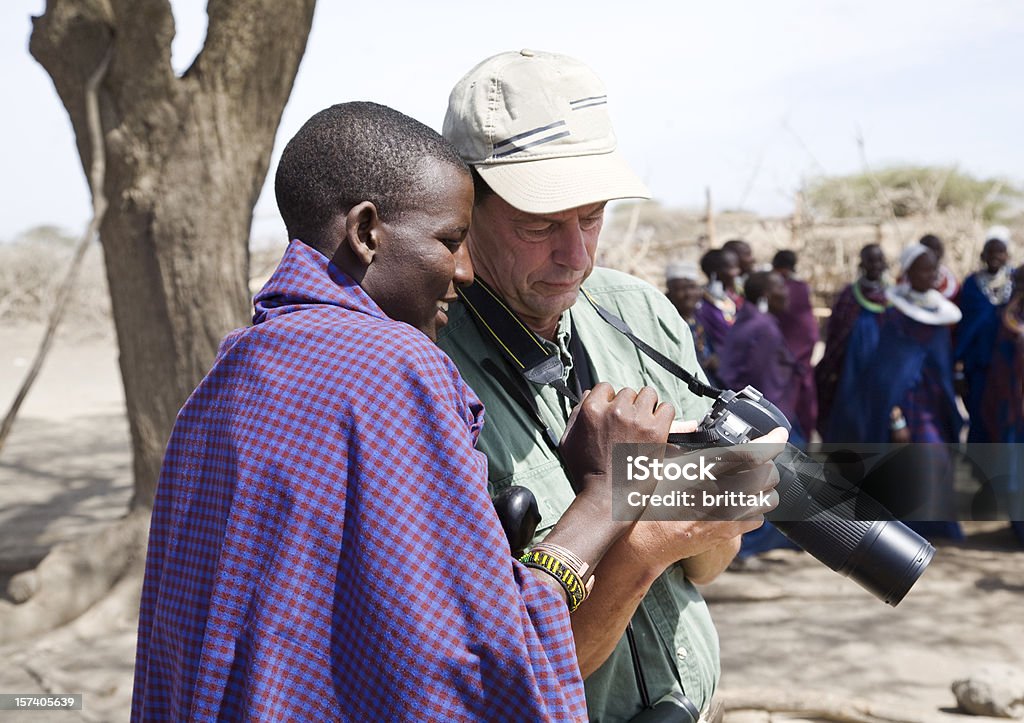 Jovem guerreiro Masai lokking no ta "da câmera. - Foto de stock de Rindo royalty-free