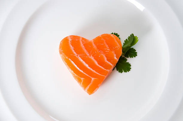 Close-up top view on a piece of smoked salmon or trout served with slides of lemon, red onion, capers, and decorated by dill and capers