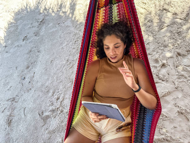 istock Latin woman on video call lying in a hammock 1574066643