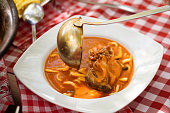 hot chili paprikaš soup with fresh catch of the day of Danube fish, red paprika and homemade pasta