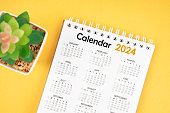 The 12 months desk calendar 2024 on yellow background.