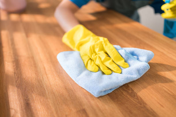 nahaufnahme professioneller hände einer asiatischen reinigungsfrau mit gelben gummihandschuhen, die mit einem lappen auf der hölzernen küchentheke zu hause abwischen. housekeeping-aufräumarbeiten, reinigung. - cleaning domestic kitchen counter top housework stock-fotos und bilder