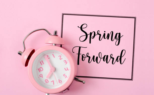 istock The Spring Forward with an alarm clock on pink color background. 1574103661