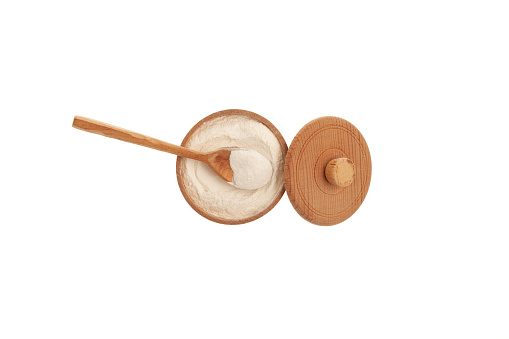 Xanthan Gum Powder in wooden spoon and bowl. Design element. Food additive E415. Xanthan gum is an extracellular polysaccharide secreted by the micro-organism Xanthomonas campestris.