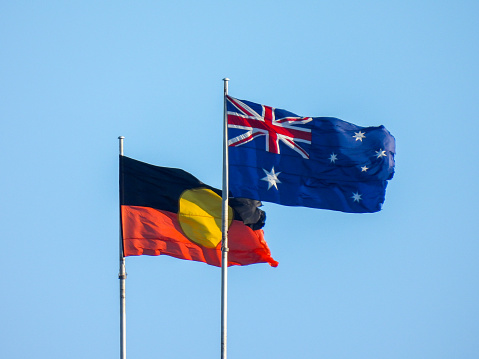 The Australian and Australian Aboriginal flags fly on the Sydney Harbour Bridge on a windy and sunny early morning in winter.  This image was taken from Mrs Macquarie's Chair on 19 July 2023.