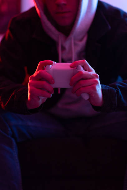 istock Young man playing video games, while sitting on the couch. 1574135120