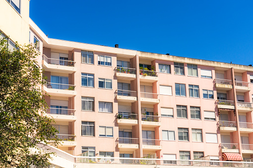 A low-rise pink apartment block with balconies in Porto, Portugal.